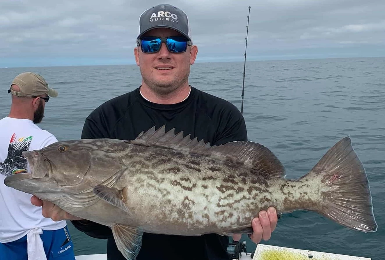 Customers holding 2 Grouper caught on charter.